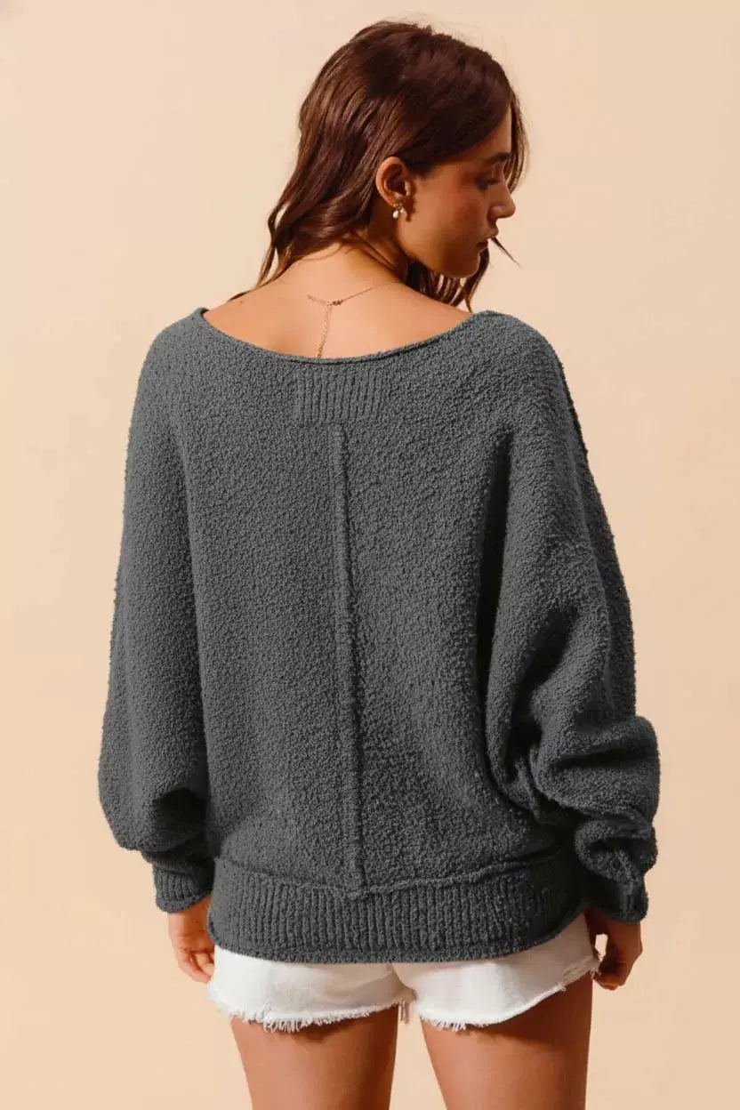 Back and drape view of exposed seam slouchy boucle sweater in grey