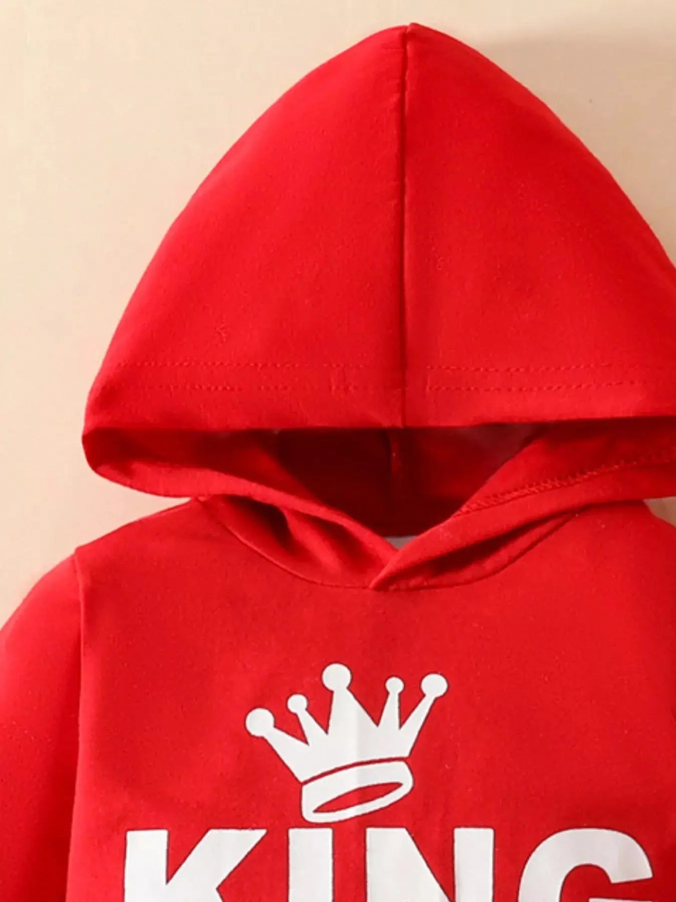 Close-up of KING crown logo on hoodie front.