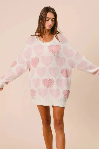 BiBi heart pattern sweater with pearl details in pink on model posing with arms out