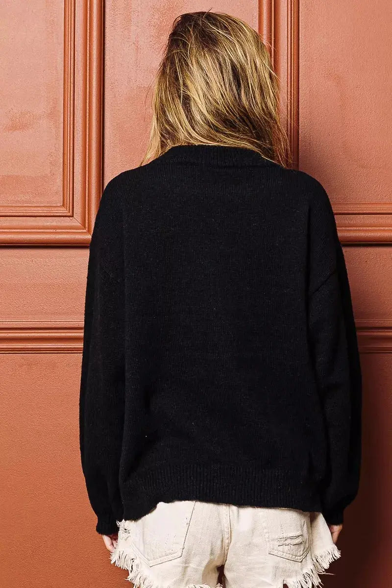 Side pose of festive embroidered Christmas sweater.