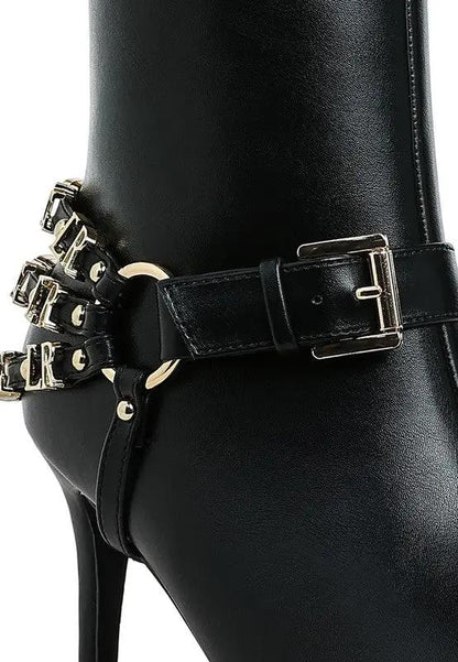 Close-up of gold buckle belt harness detail on women’s stiletto boots.
