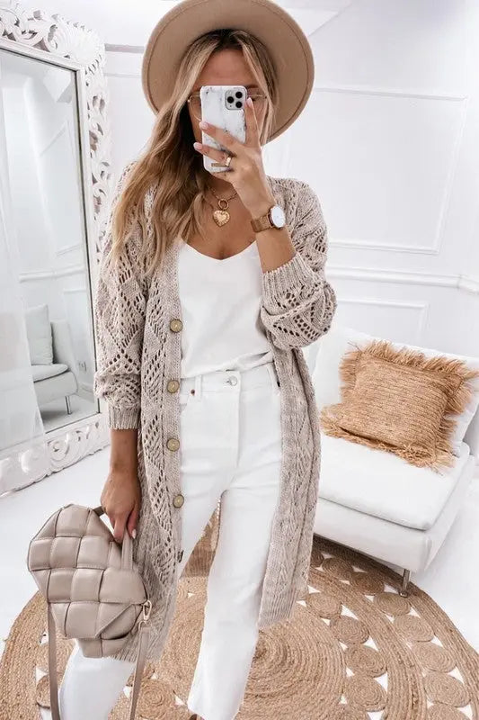 Eyelet button cardigan in beige styled casually on female model holding handbag.