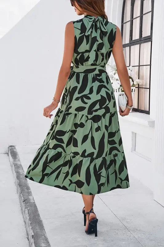Sleeveless halter midi dress with tie back detail on female model.