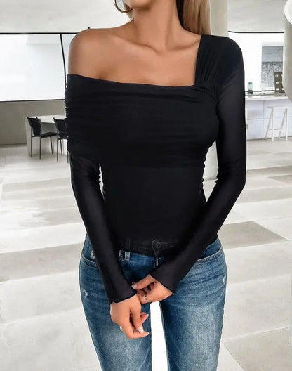 Asymmetrical one-shoulder blouse styled with jeans in the color black on female model