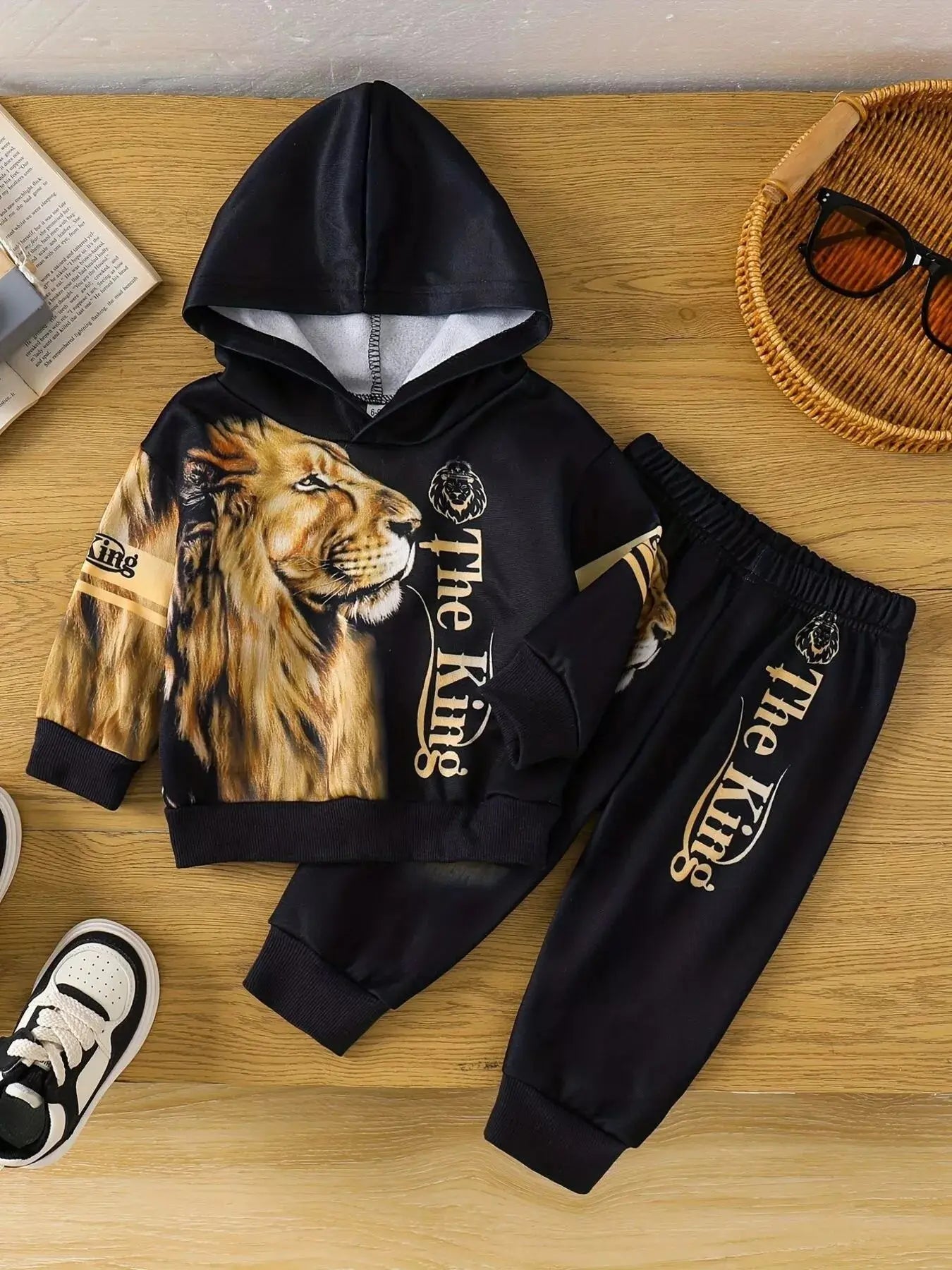 Flat lay of children’s Lion King hoodie and jogger pants set with lion graphic.