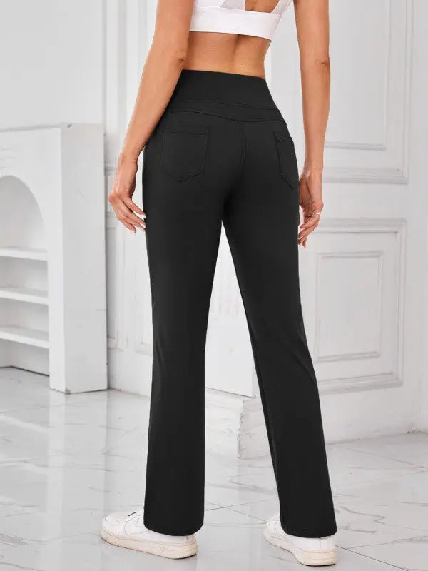 Woman wearing black high-waisted active pants with pockets by JupiterGear - back view