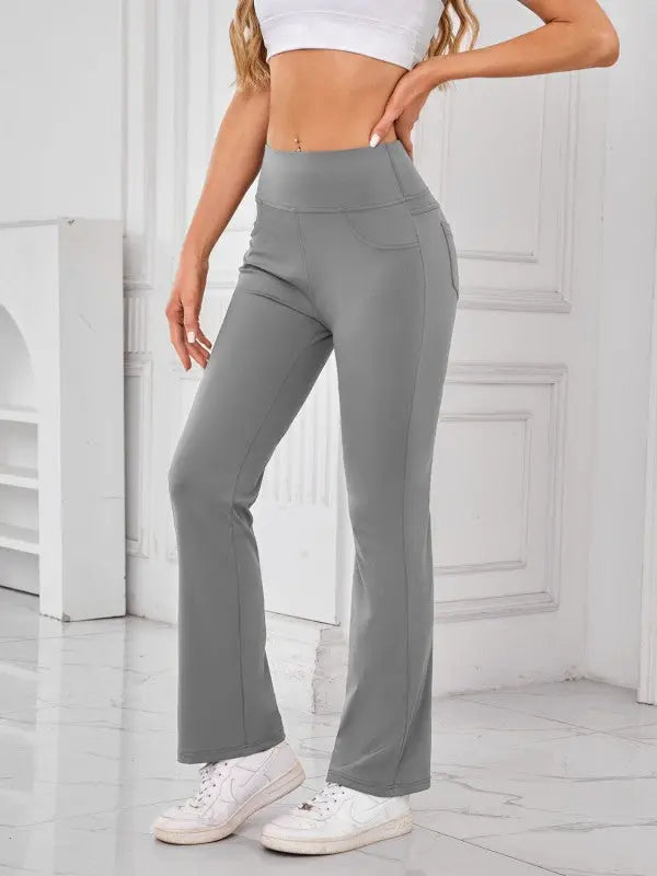 Woman wearing gray high-waisted active pants with pockets by JupiterGear - front view