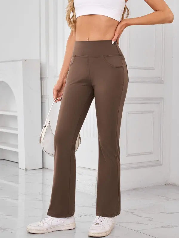 Woman wearing brown high-waisted active pants with pockets by JupiterGear - front view