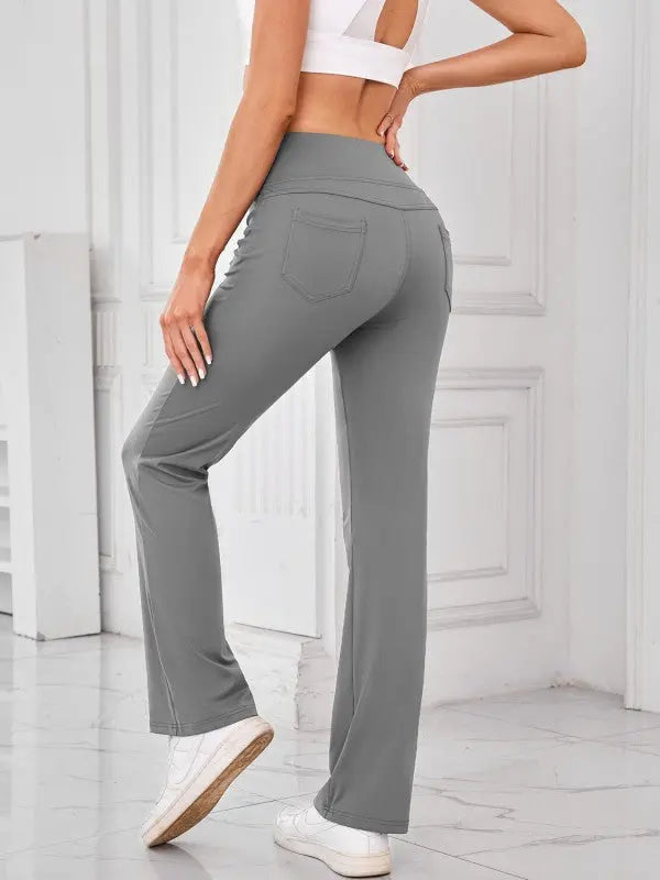 Woman wearing gray high-waisted active pants with pockets by JupiterGear - back view