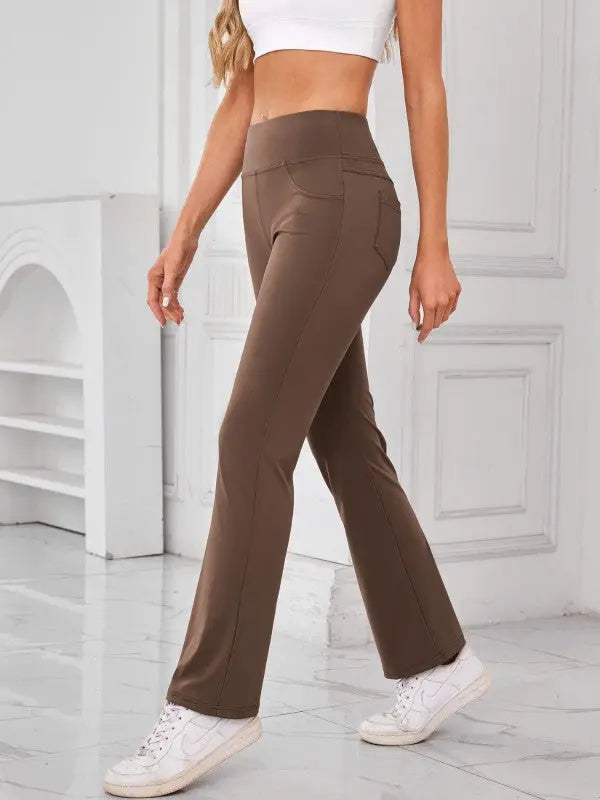 Woman wearing brown high-waisted active pants with pockets by JupiterGear - side view