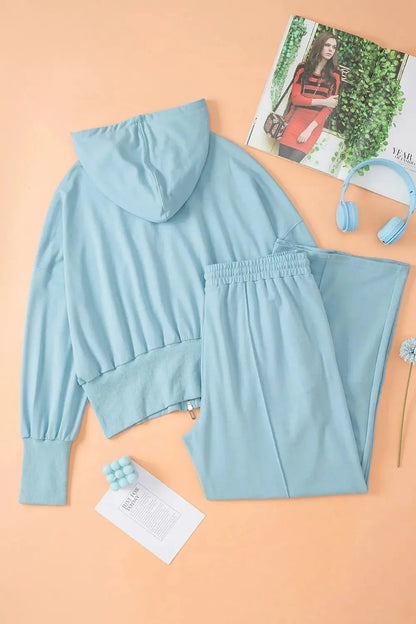 Flat lay of light blue zip-up hoodie and wide leg pants active set.