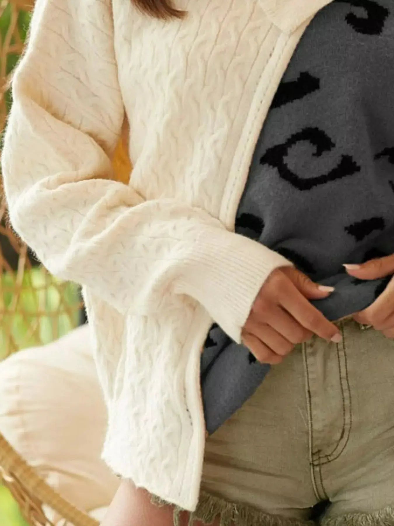 Close-up of cable-knit texture and one-shoulder design - front view