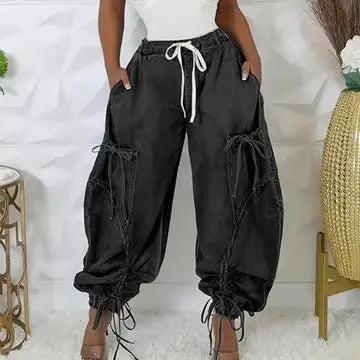 Black wide-leg pants with drawstring waist worn by a person on a white background