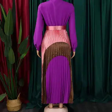 Purple and pink dress with a fringed skirt against a green curtain background
