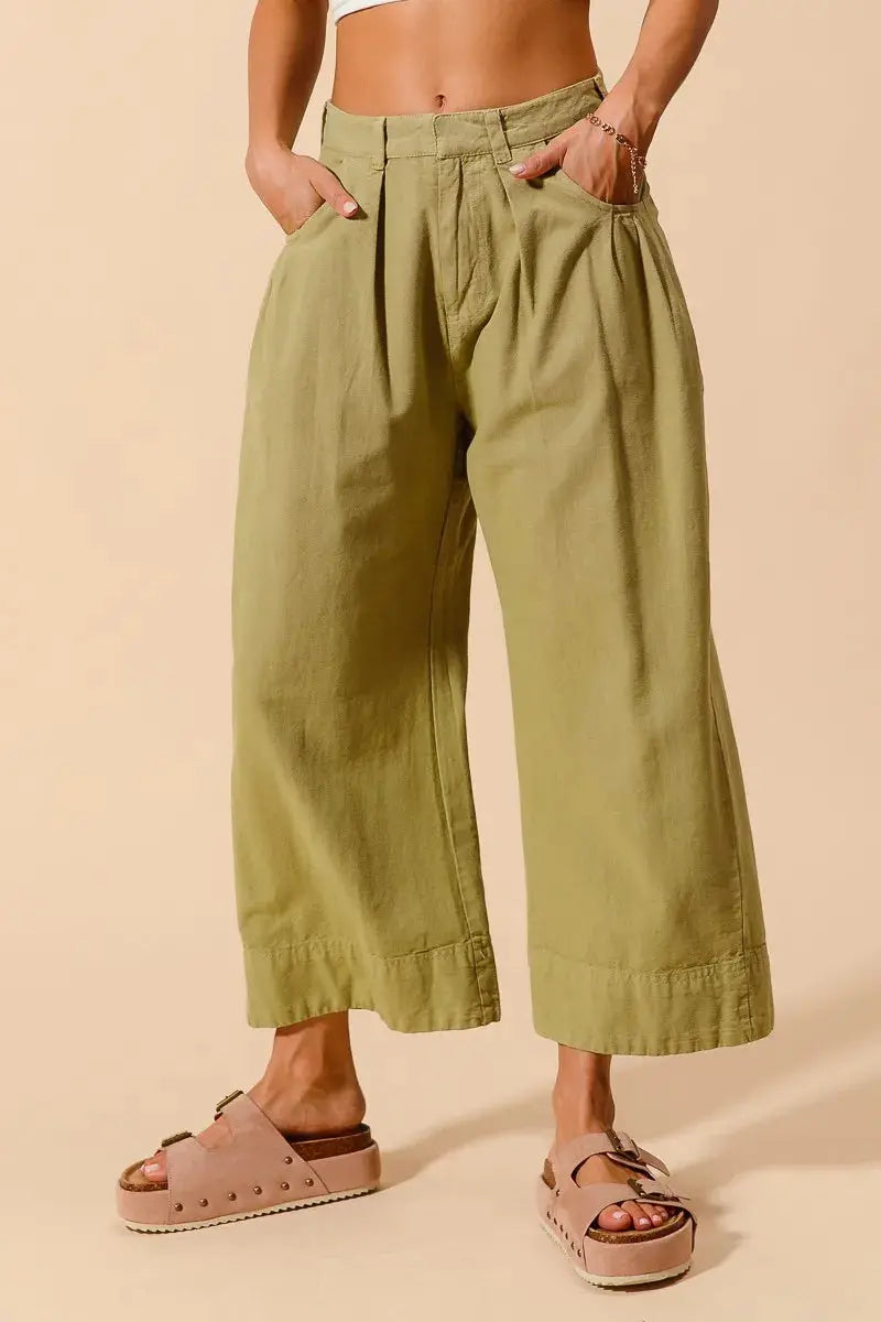 Close-up of waistband and pleated front design on olive chino pants om female model