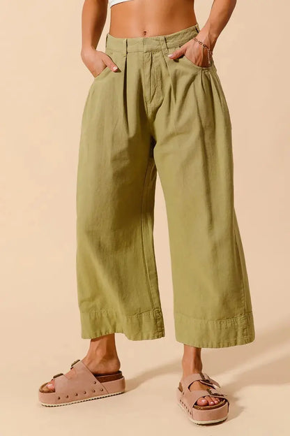 Close-up of waistband and pleated front design on olive chino pants om female model