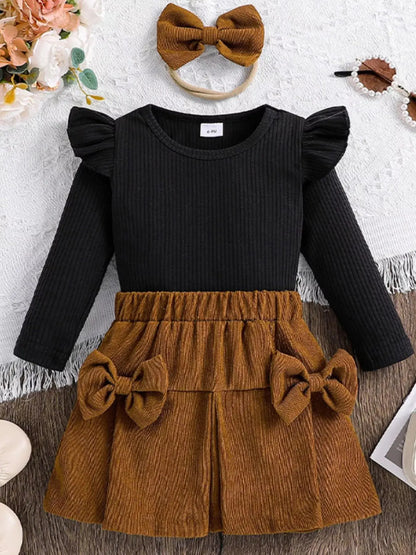 Front view of children’s ribbed top and bow skirt set with matching headband in brown and black.