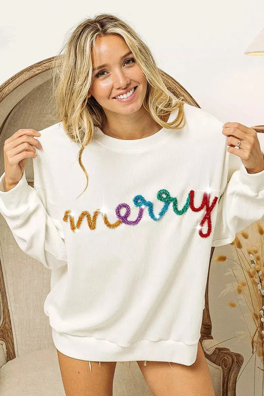 Model wearing oversized Merry tinsel lettering sweatshirt.