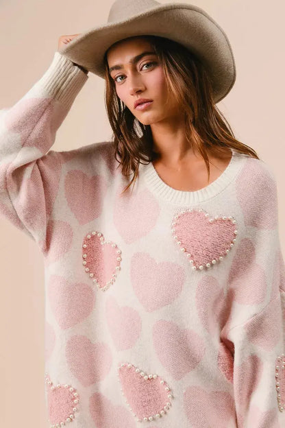 BiBi heart pattern sweater with pearl details in pink on female model posing with hat