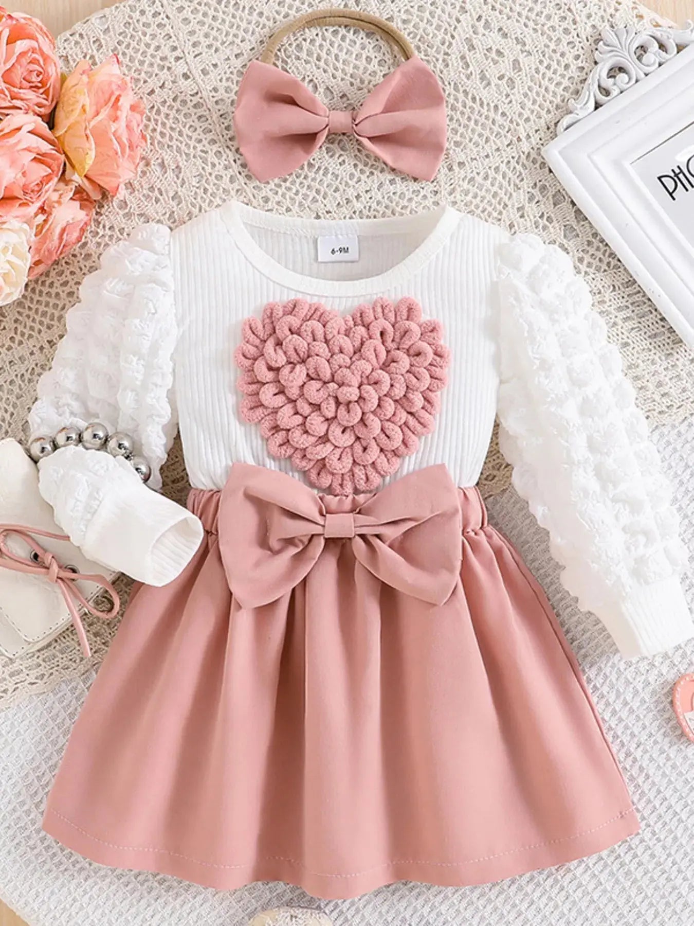 Front view of pink children’s heart bowknot dress with matching headband.