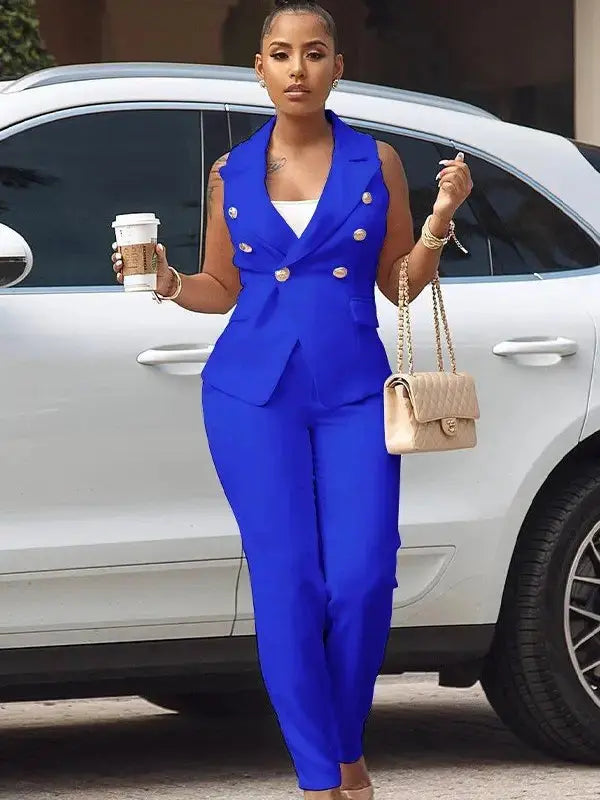 Woman wearing royal blue blazer tank pants set holding a coffee cup near white car.