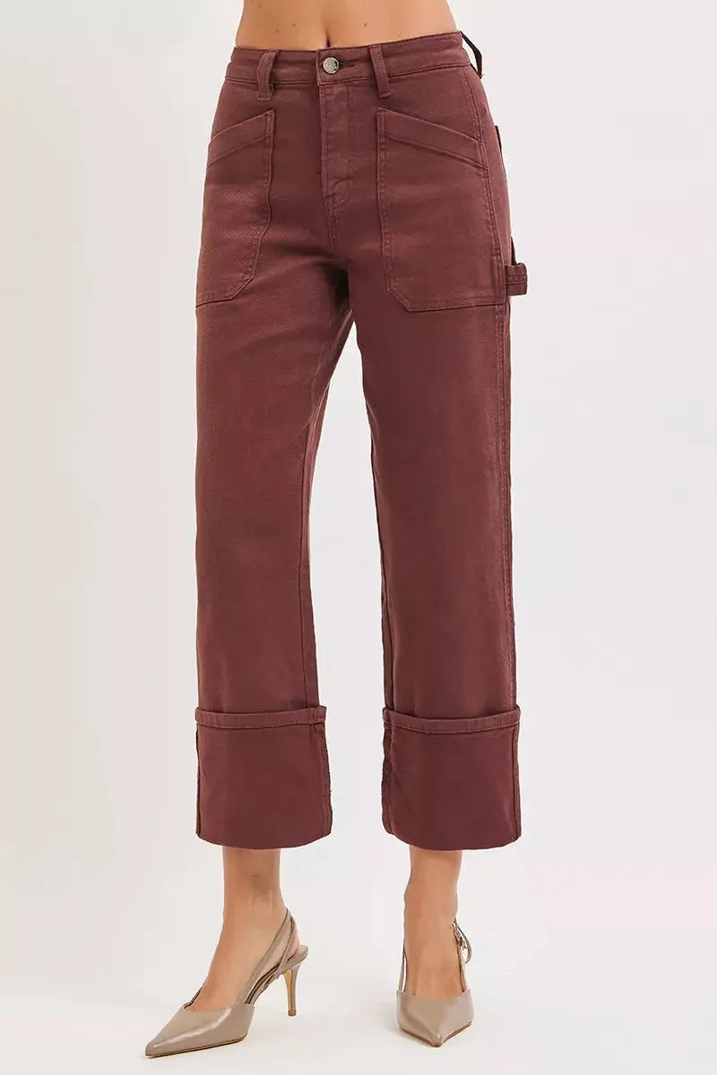 slanted model pose of burgundy wide-leg cuffed jeans with carpenter pocket detailing