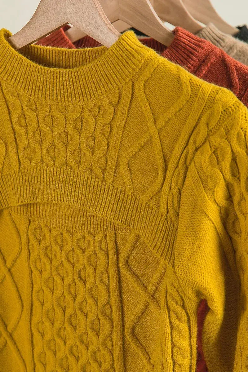 Front view of mustard yellow cable-knit cut-out sweater on hanger