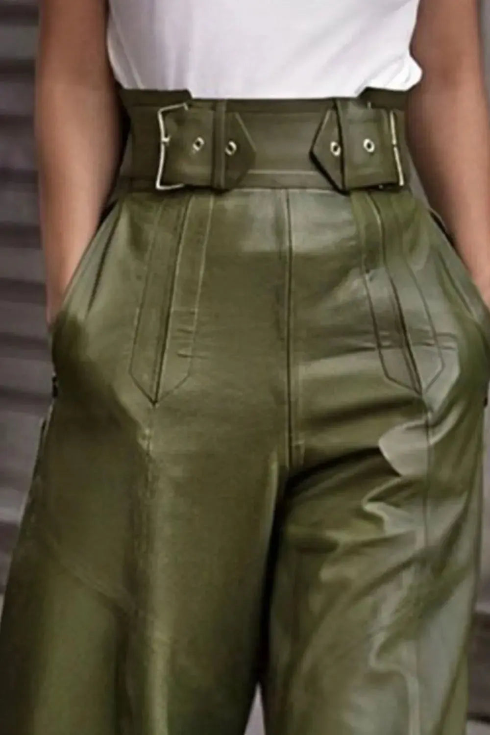 Close-up of faux leather texture and pocket detail on green flare pants.