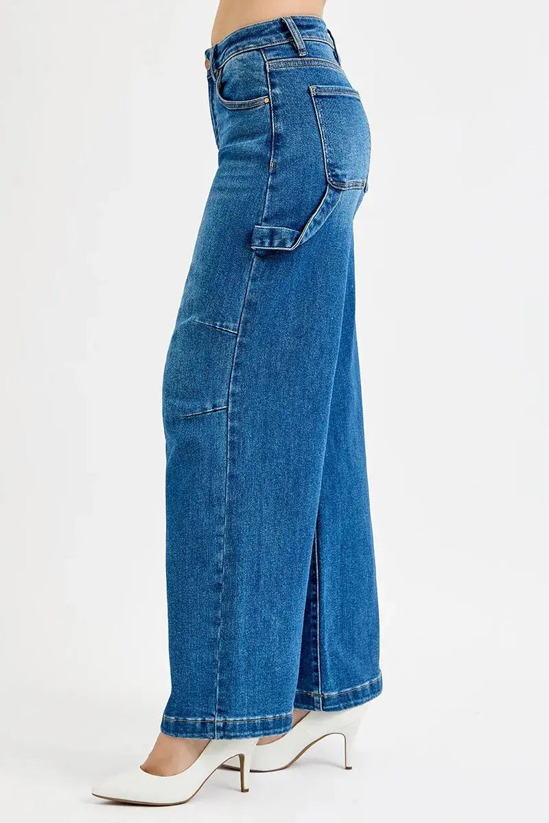 Plus size model wearing high-rise wide-leg patch detailed denim jeans (side view).