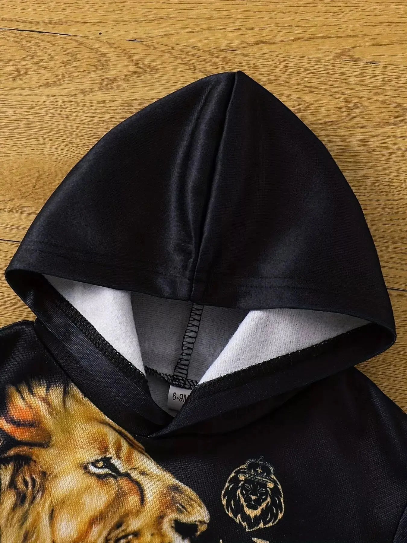 Close-up of toddler boy hoodie featuring bold lion print.