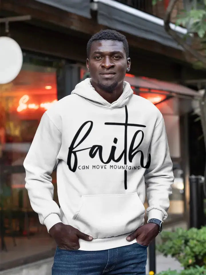 Man wearing white “Faith Can Move Mountains” hoodie outdoors.