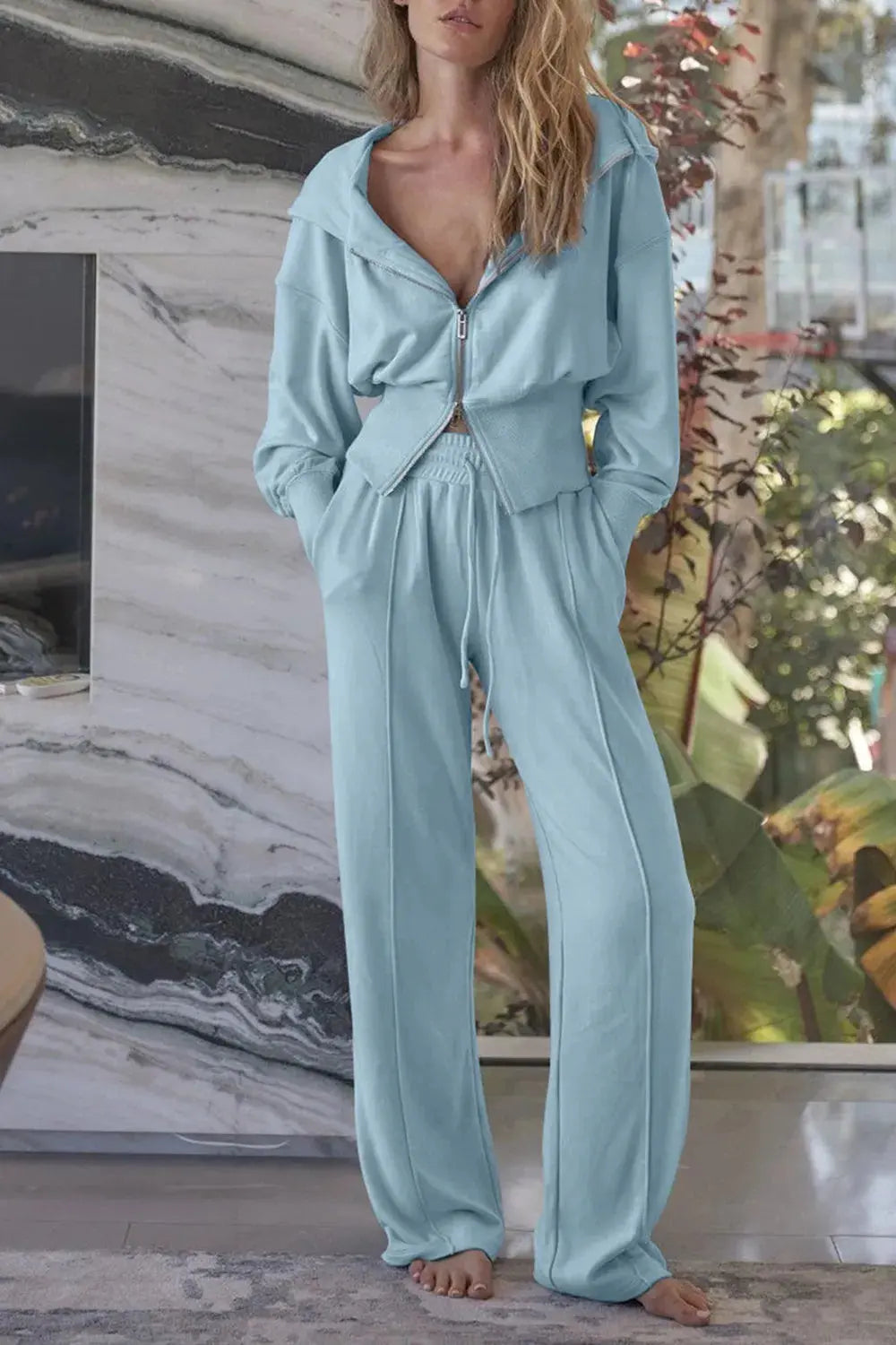 Woman wearing light  blue zip-up hoodie and wide leg pants active set.