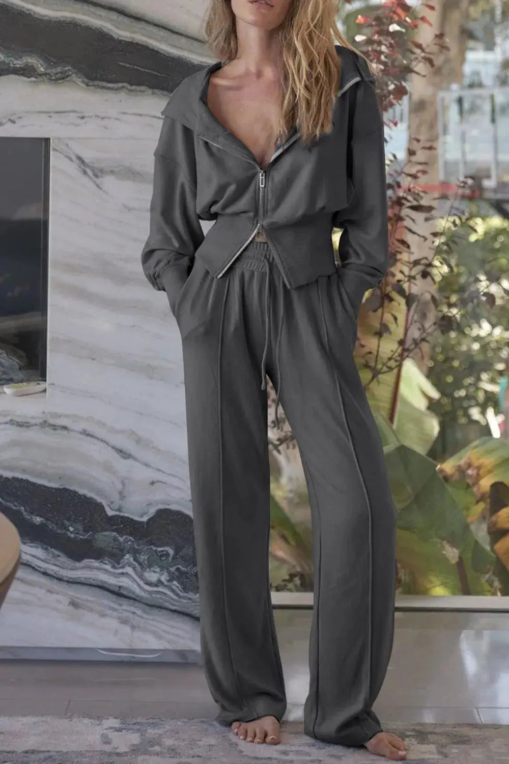 Woman wearing gray zip-up hoodie and wide leg pants active set.