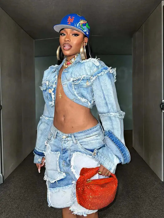  Woman wearing distressed patchwork denim jacket and skirt set posing in hallway.