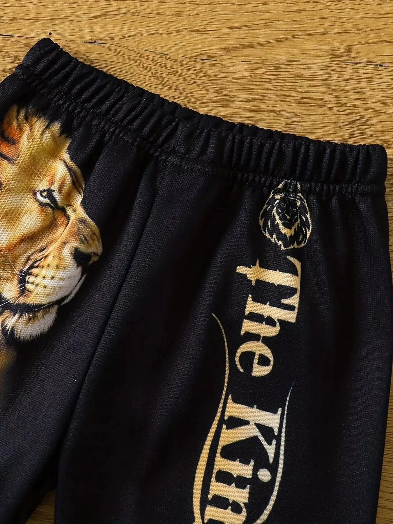Close-up of toddler boy bottoms featuring bold lion print.