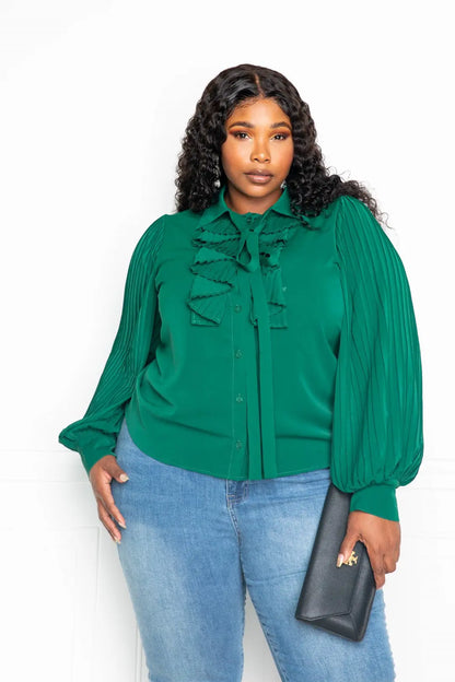 Woman wearing green pleated sleeve blouse with waterfall frill and bow – front view