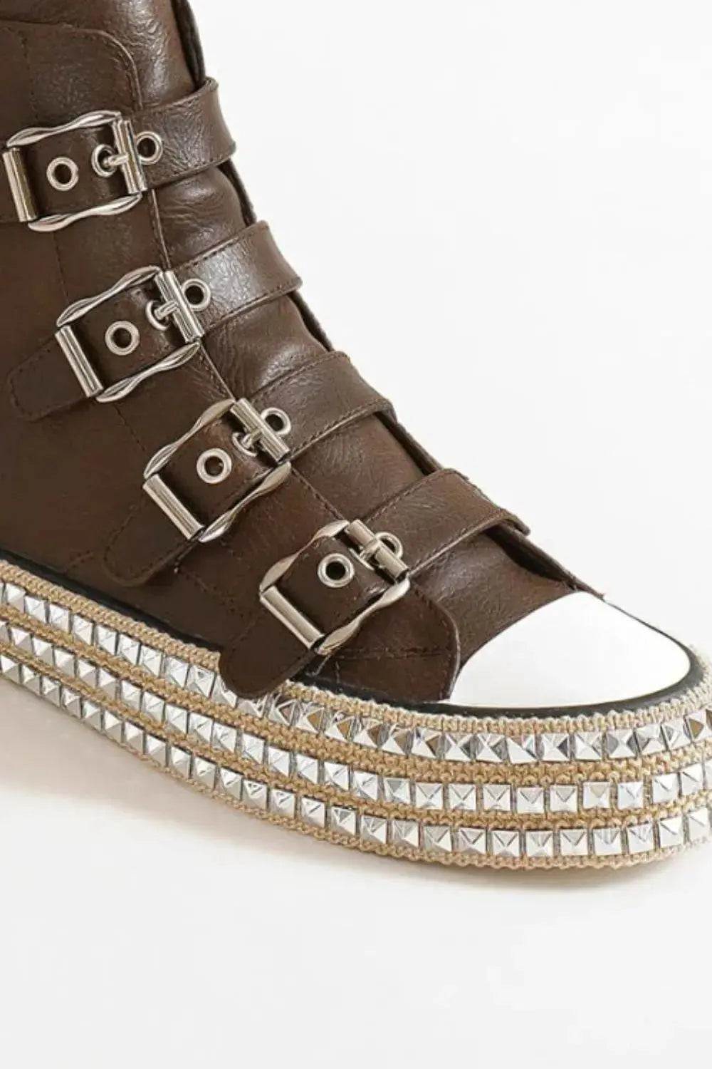 Close-up of buckle straps and metal studs on platform sneakers