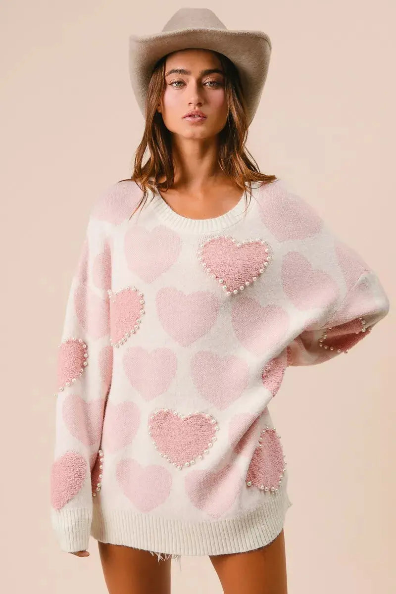 BiBi heart pattern sweater with pearl details in pink on female model.