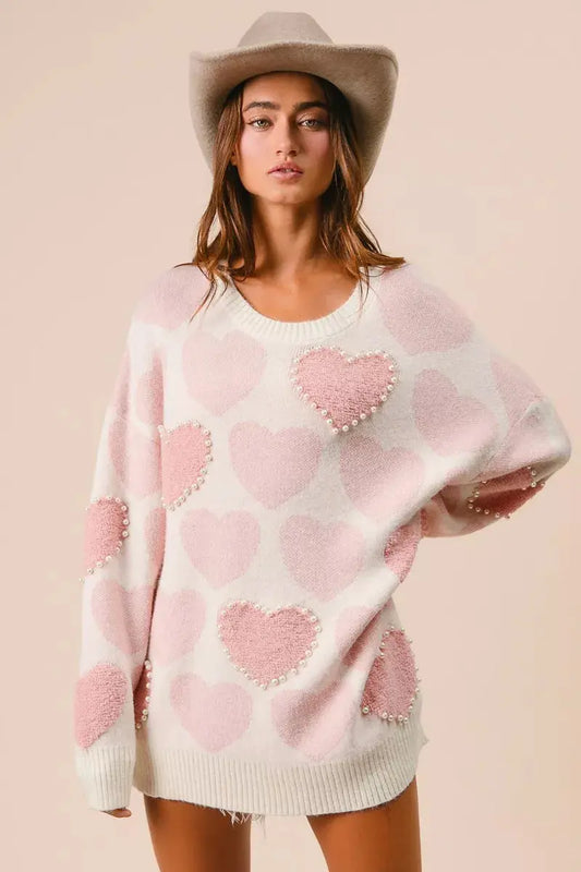 BiBi heart pattern sweater with pearl details in pink on female model.