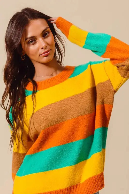 Model posing in bright striped sweater – Couture Envy