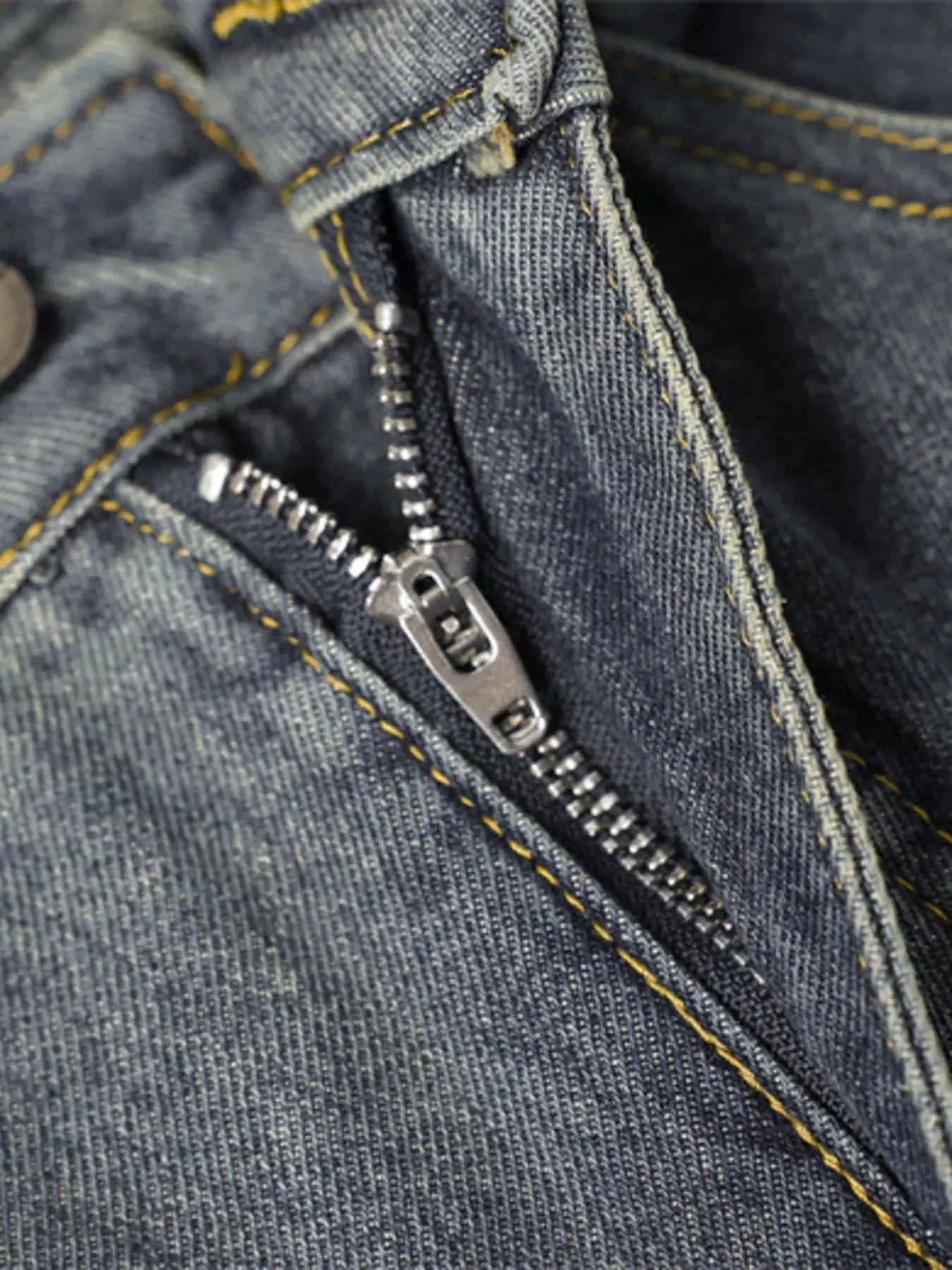 Close-up of Men’s Wide Leg Jeans with Frayed Seam details of denim  zipper closure.