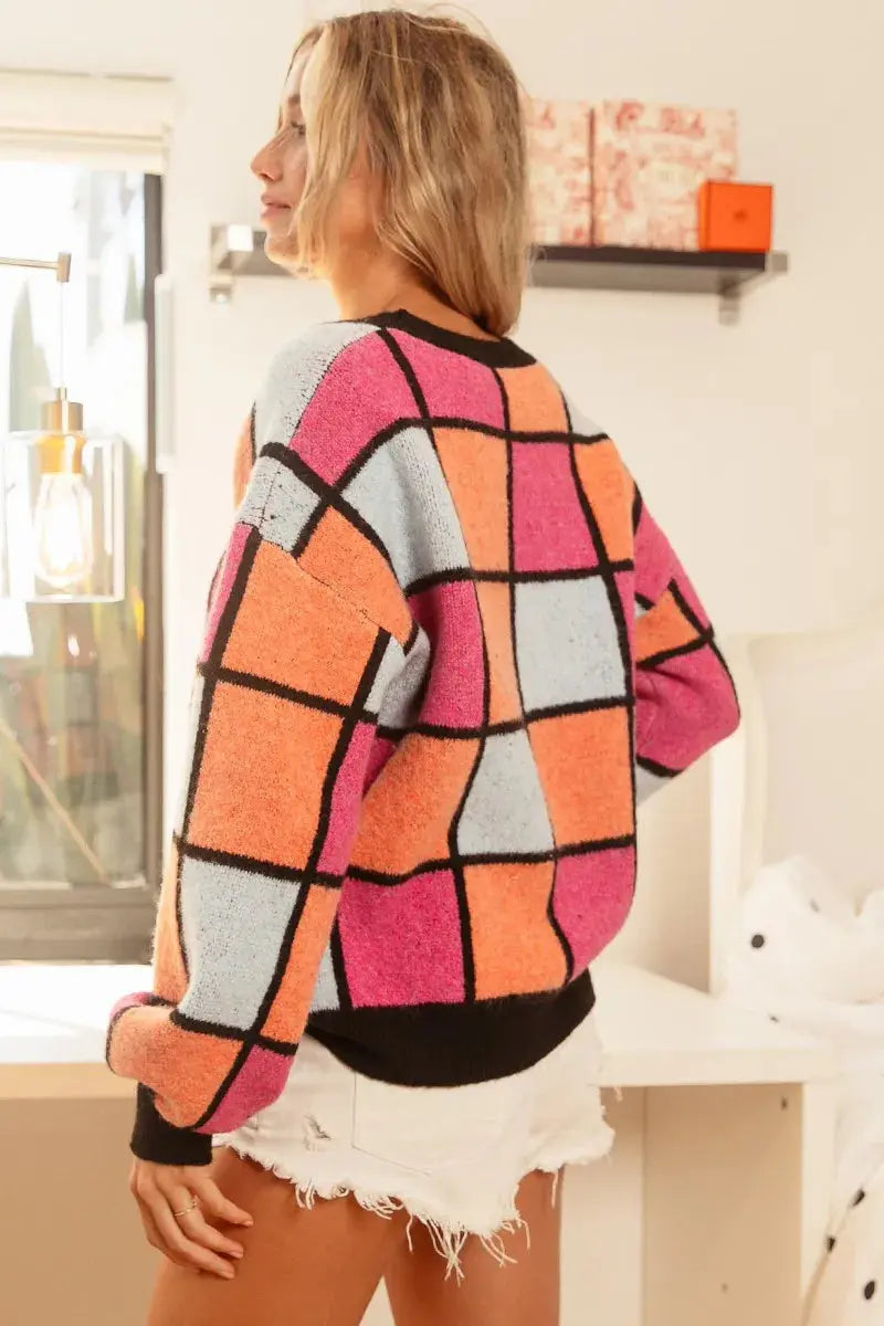 Model wearing BiBi checker sweater—playful pose - slanted back view.