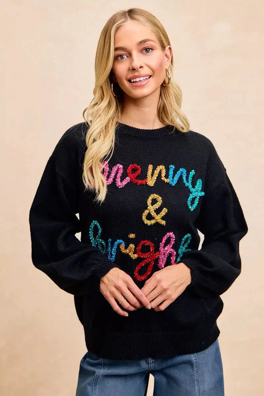 Model wearing black Christmas sweater with multicolor tinsel lettering.