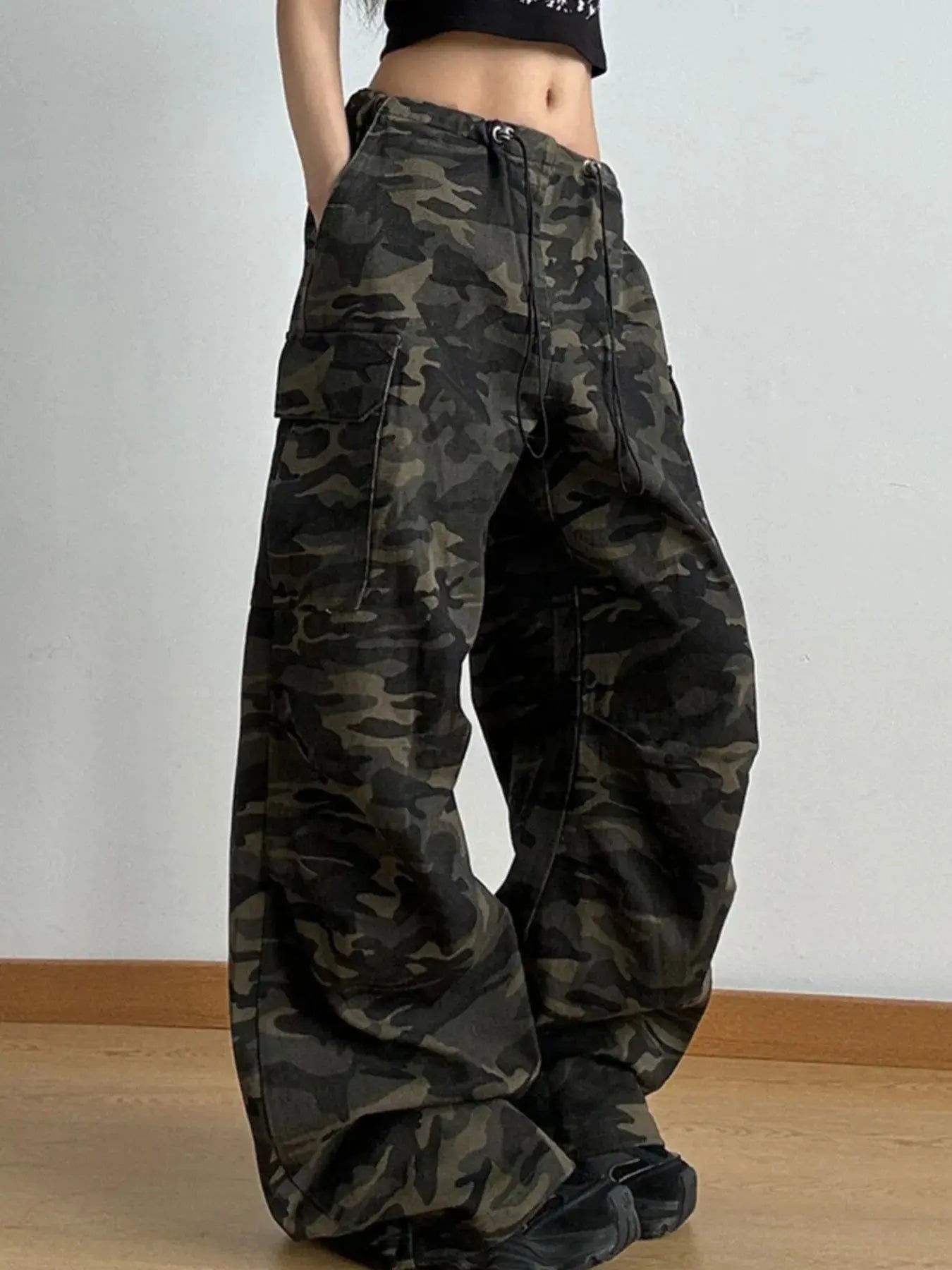 Side view of camo cargo pants for women featuring wide leg cut and utility pockets.