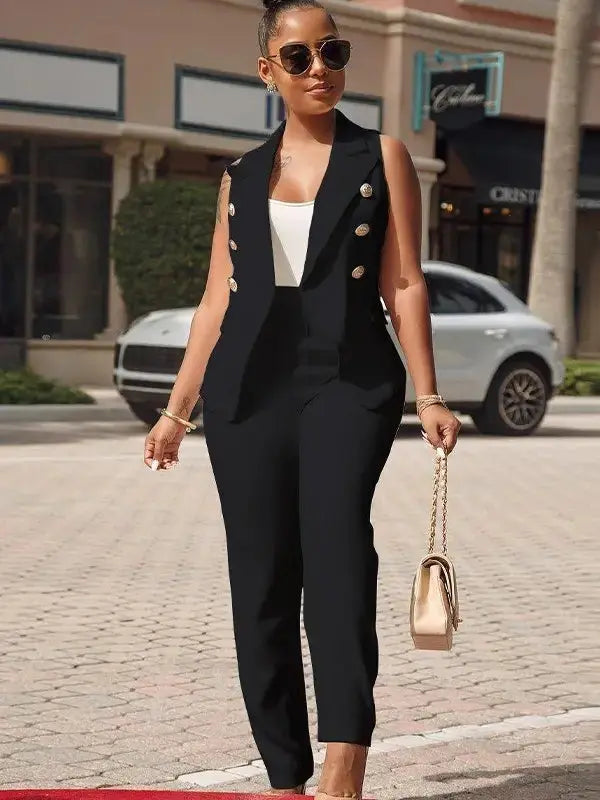 Woman wearing black tailored blazer tank and pants set standing confidently outdoors.