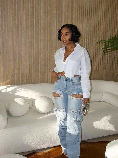Model wearing blue Distressed Wash Cargo Jeans Couture Envy posing in front of white couch