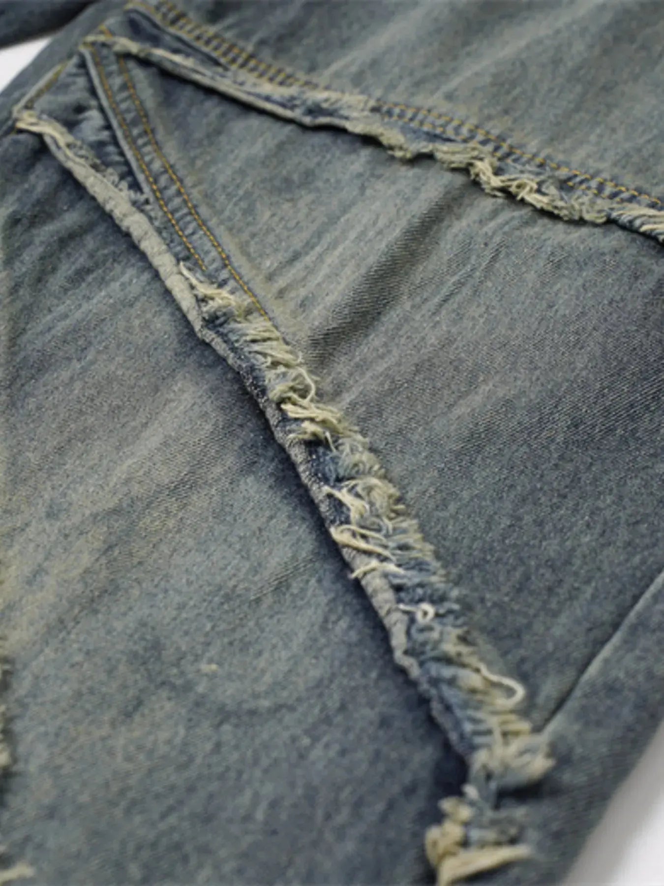 Close-up of frayed seam detailing on washed denim.