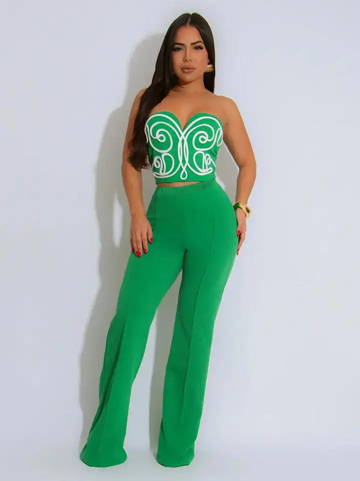 Woman wearing green strapless embroidered crop top and matching trousers