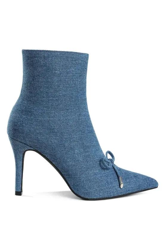 Close-up of bow accent on blue denim heeled boots.