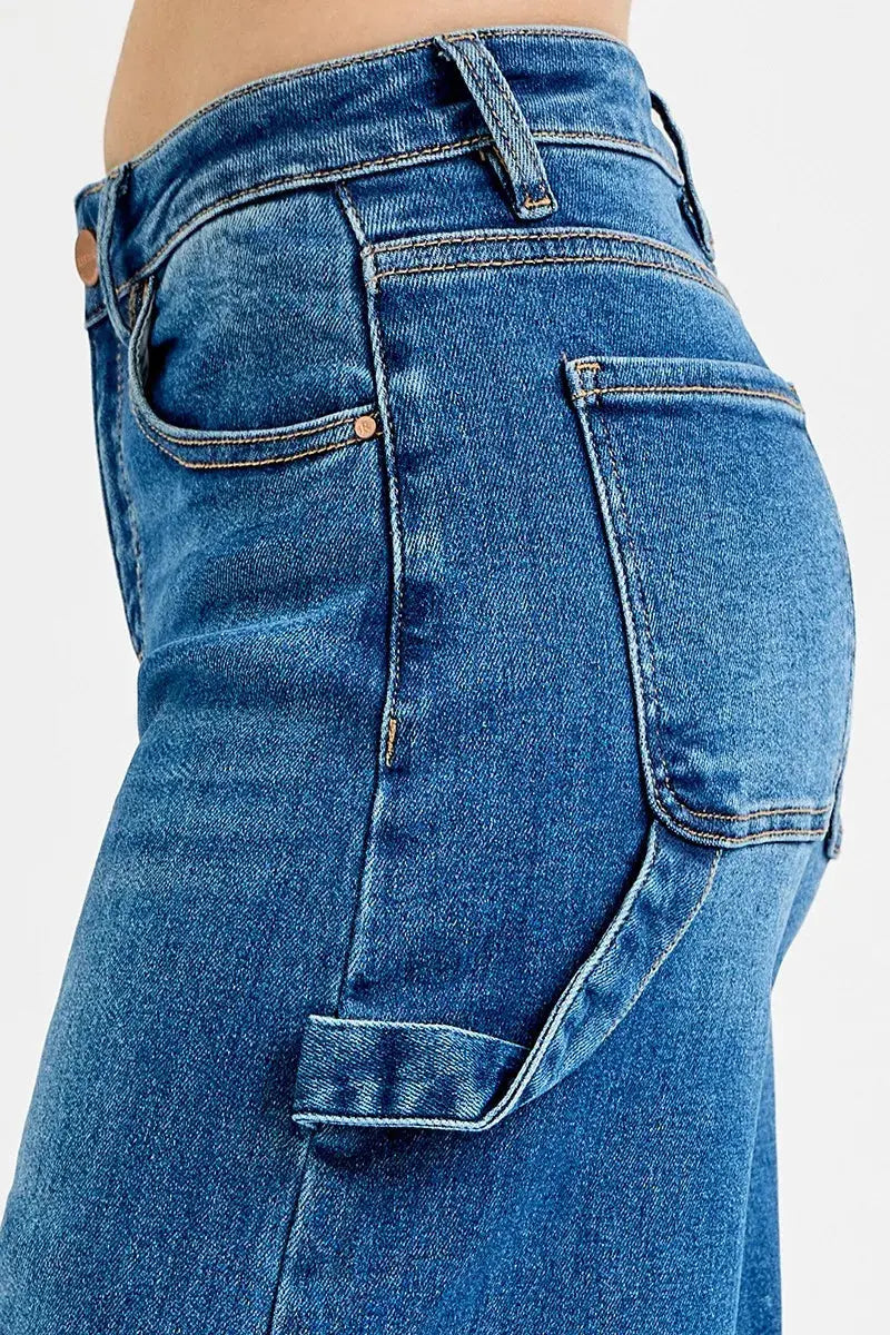 Patch detail close-up on high-rise wide-leg denim jeans.